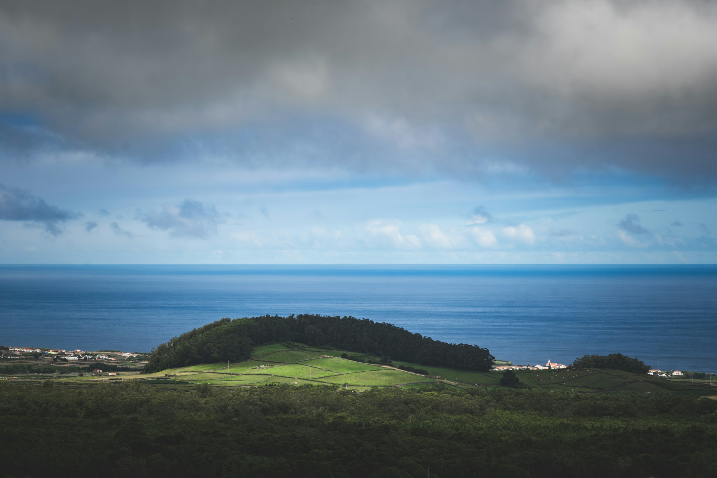A green hill overlooking the Atlantic Ocean on Terceira Island, Azores